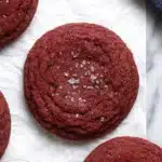 Soft red velvet cookies with sugar crystals on parchment paper