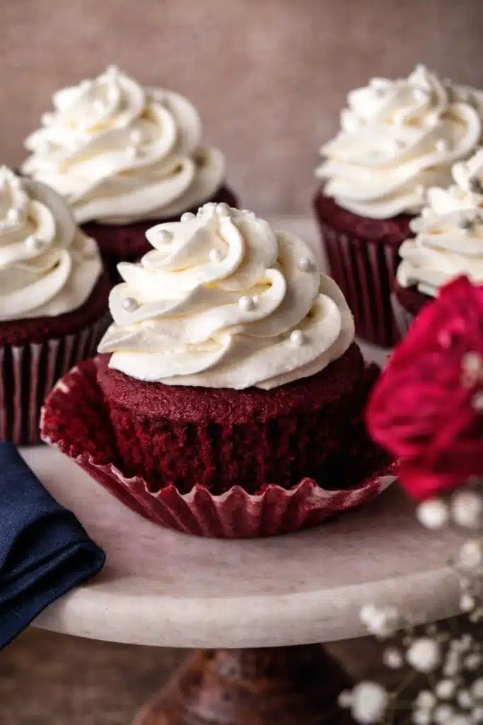 Red Velvet Cupcakes | Amazing Creamy Frosting Recipe 7 Red velvet cupcake with cream cheese frosting and sugar pearls on marble stand