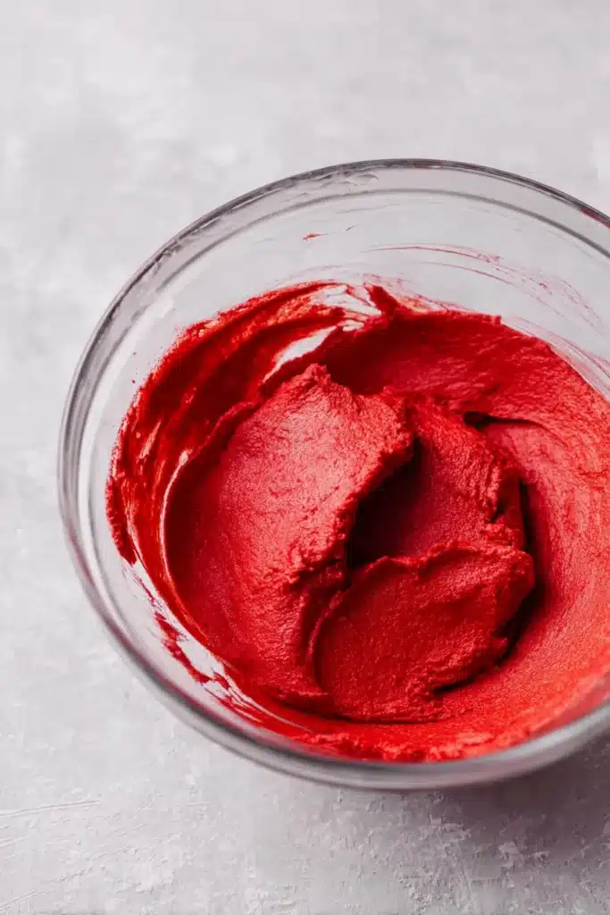 Red Velvet Cupcake Cookies | Irresistibly Soft & Creamy 14 Red velvet cupcake cookie dough in a glass bowl on gray surface