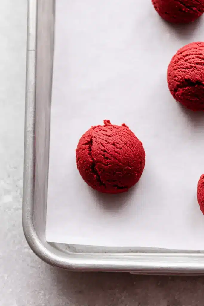 Red Velvet Cupcake Cookies | Irresistibly Soft & Creamy 16 Red velvet cupcake cookie dough balls on a parchment-lined baking sheet
