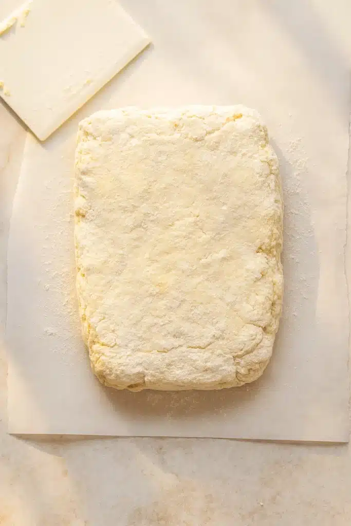 Rectangular sourdough biscuit dough slab on parchment paper