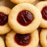 Stack of simple Christmas jam thumbprint cookies with raspberry filling