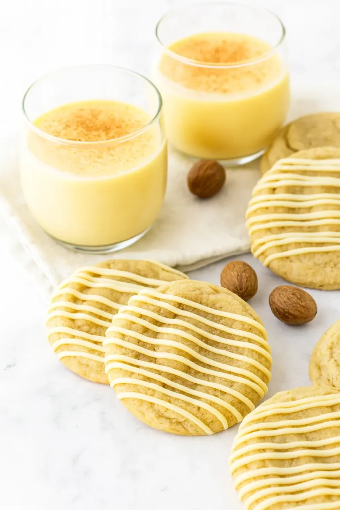 Eggnog Cookies | Soft, Chewy & Perfect for the Holidays 9 Soft eggnog cookies with icing drizzle on gray table and white napkin