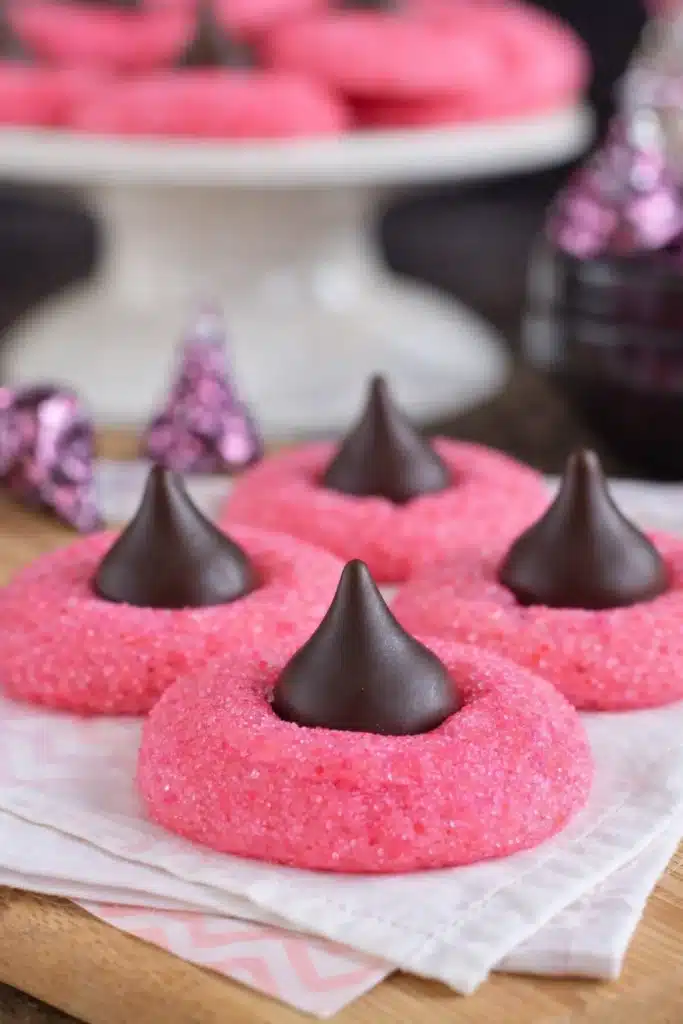 Close-up of strawberry kiss cookies with chocolate truffles on white napkin