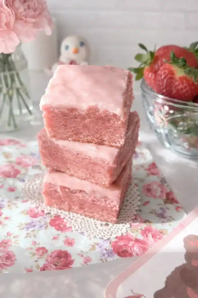 Strawberry Sweetheart Brownies | Amazing Valentine’s Treat 7 Stack of strawberry sweetheart brownies with pink icing on floral napkin