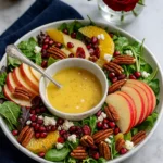 Sweet Christmas apple salad with oranges, feta, and pecans on a holiday table