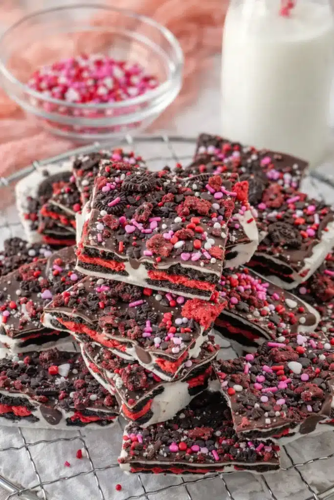Valentine’s Day Oreo Cookie Bark | Amazing No-Bake Treat 6 Valentine’s Day Oreo cookie bark stacked on a white napkin with milk and sprinkles