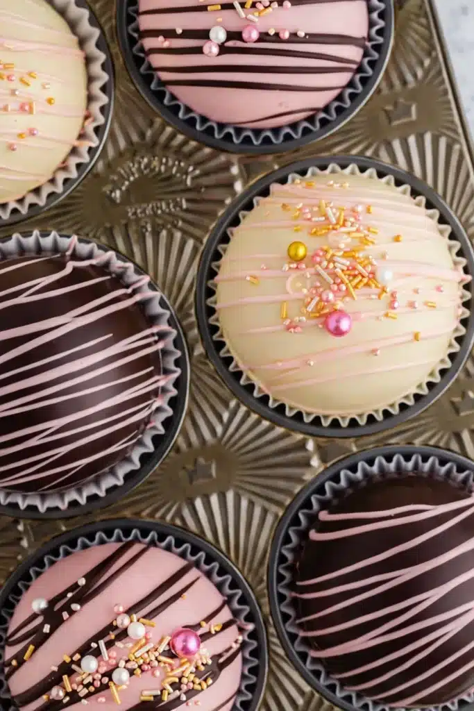 Valentine’s Hot Chocolate Bombs | Easy, Romantic & Fun 7 Overhead view of Valentine’s hot chocolate bombs with pink drizzle and sprinkles