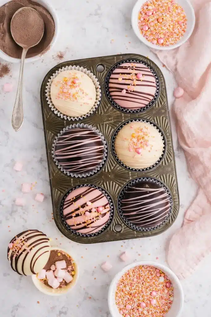 Assorted Valentine’s hot chocolate bombs with pink and white chocolate and festive sprinkles