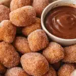 Air fryer churro bites coated in sugar with chocolate dipping sauce