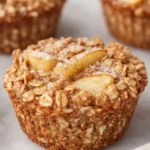 Close-up of baked apple cinnamon oatmeal cup with oats and apple slices