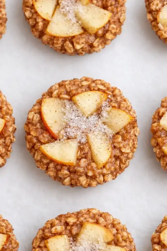 Baked Apple Cinnamon Oatmeal Cups | Amazing Cozy Breakfast 6 Top-down view of baked apple cinnamon oatmeal cups with oats and apple slices