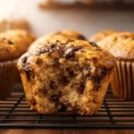 Moist banana bread muffin with chocolate chips on cooling rack