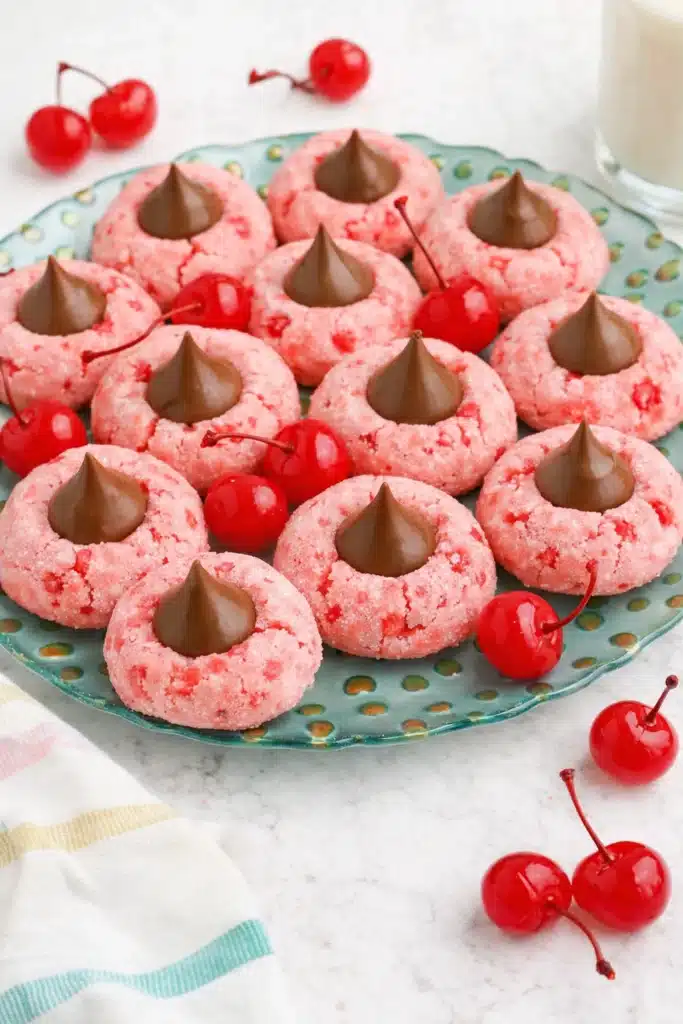 Plate of Cherry Blossom Cookies with chocolate kisses and cherries on marble background