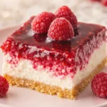 Close-up of creamy raspberry cheesecake slice with glossy raspberry topping
