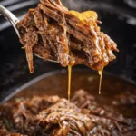 Tender crock pot French onion pot roast lifted from slow cooker with onion gravy