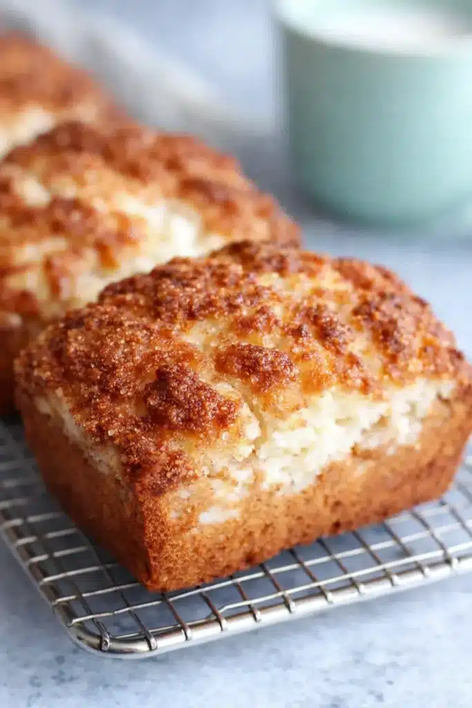 Mini vanilla eggnog bread loaves with crumb topping on cooling rack