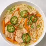 Ginger garlic chicken noodle soup with jalapeños, carrots, and chili oil