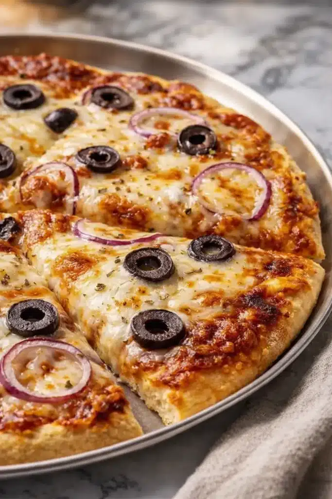Easy Greek yogurt pizza with golden crust, black olives, and melted cheese