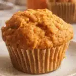 Greek yogurt pumpkin muffin on a plate with warm fall lighting
