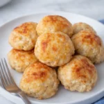 Golden ground chicken meatballs on a white plate with fork
