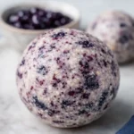 Healthy Blueberry Protein Balls on marble plate with fresh blueberries