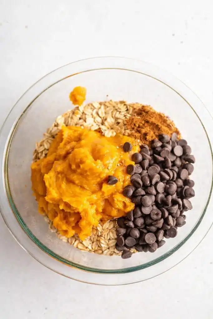 Healthy Pumpkin Oat Cookies | Easy & Delicious Treat 8 Glass bowl with pumpkin puree, oats, and chocolate chips for healthy pumpkin oat cookies