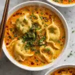 Bowl of quick coconut curry soup with dumplings and scallions