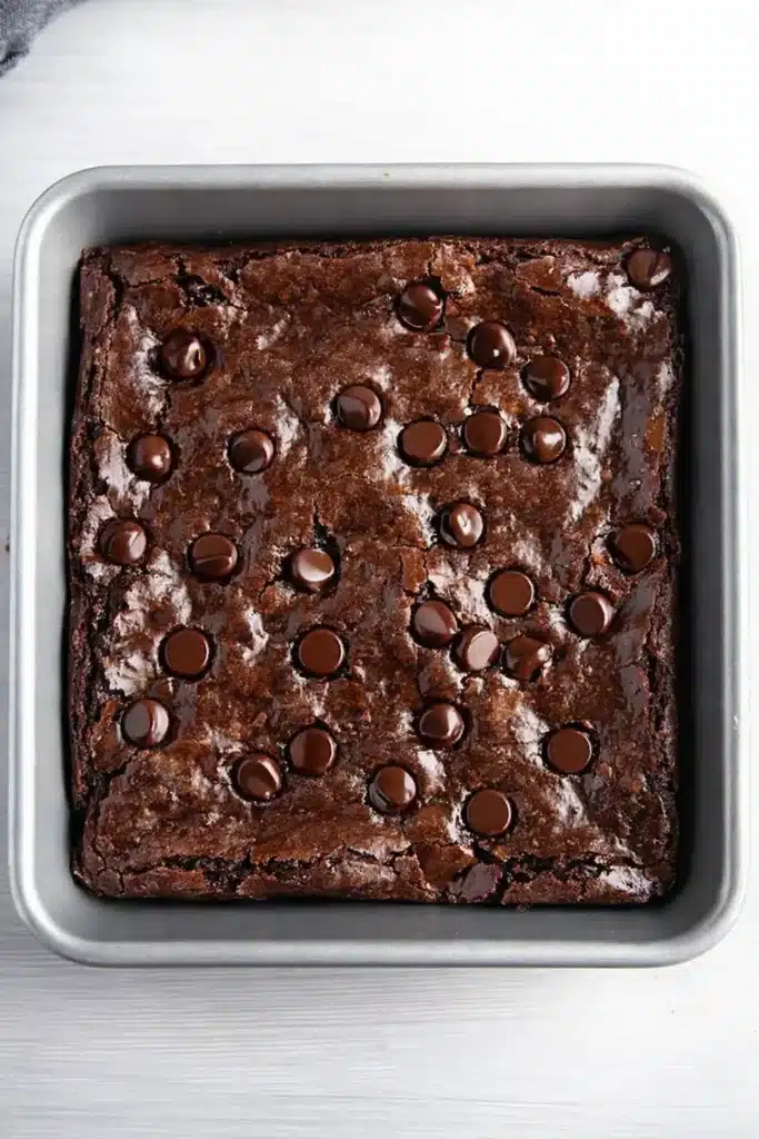 Fudgy gluten-free brownies in a silver baking pan with glossy tops