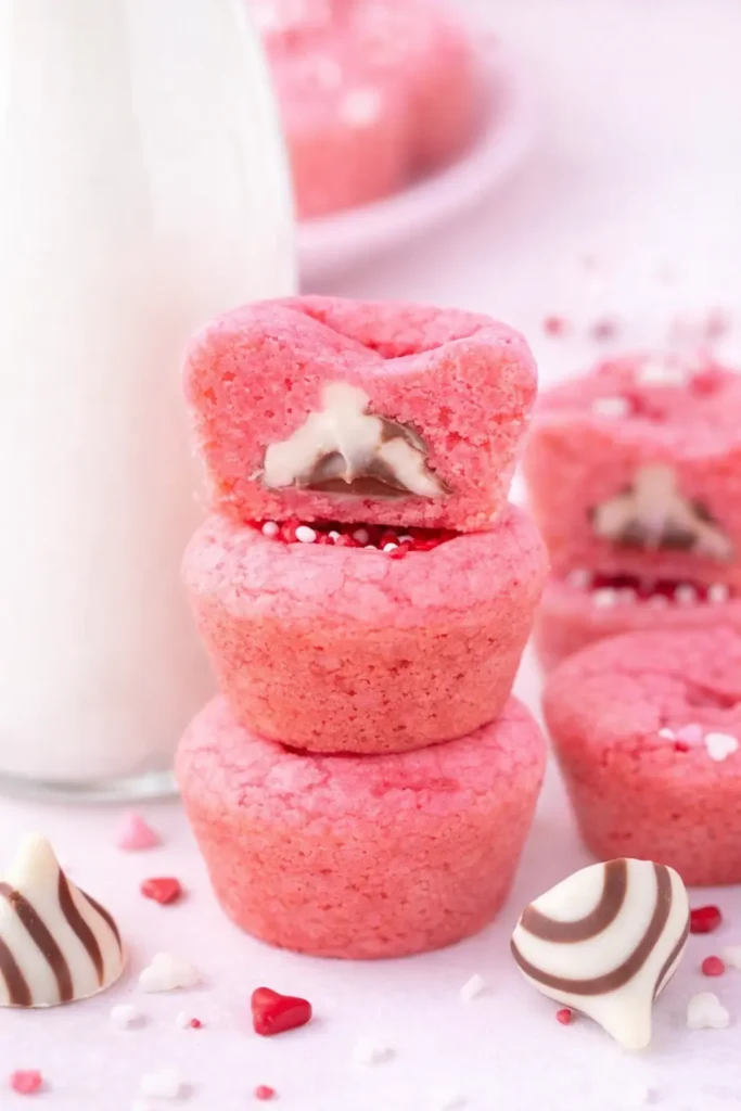 Stack of pink Valentine’s Day cookie cups with chocolate centers and milk bottle
