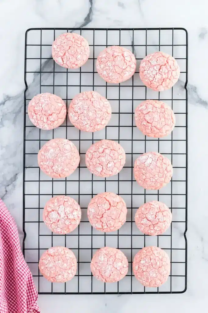 Strawberry Crinkle Cookies | Quick, Amazing Dessert Recipe 6 Strawberry crinkle cookies cooling on a wire rack over marble surface
