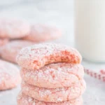 Stack of strawberry crinkle cookies dusted with powdered sugar