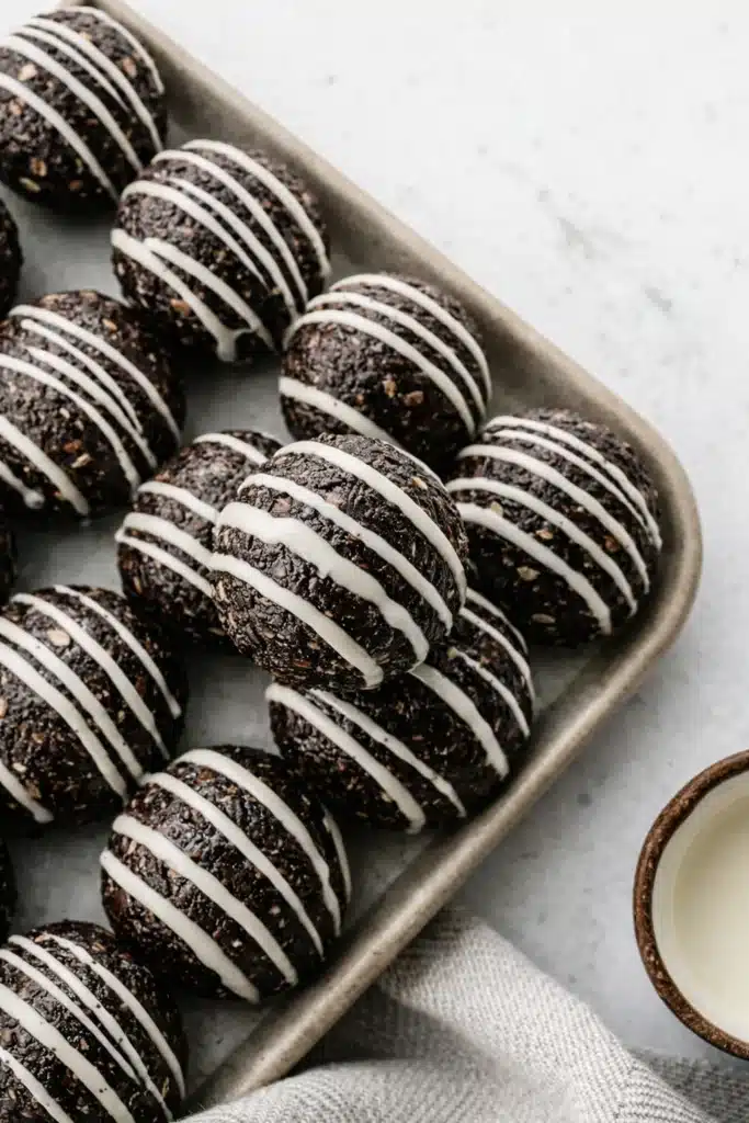 Tasty Oreo Protein Balls Recipe | Amazing No-Bake Snack 5 Tasty Oreo protein balls with white chocolate drizzle on tray