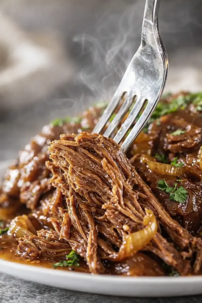 Fork pulling tender Crock Pot French onion pot roast with rich onion gravy