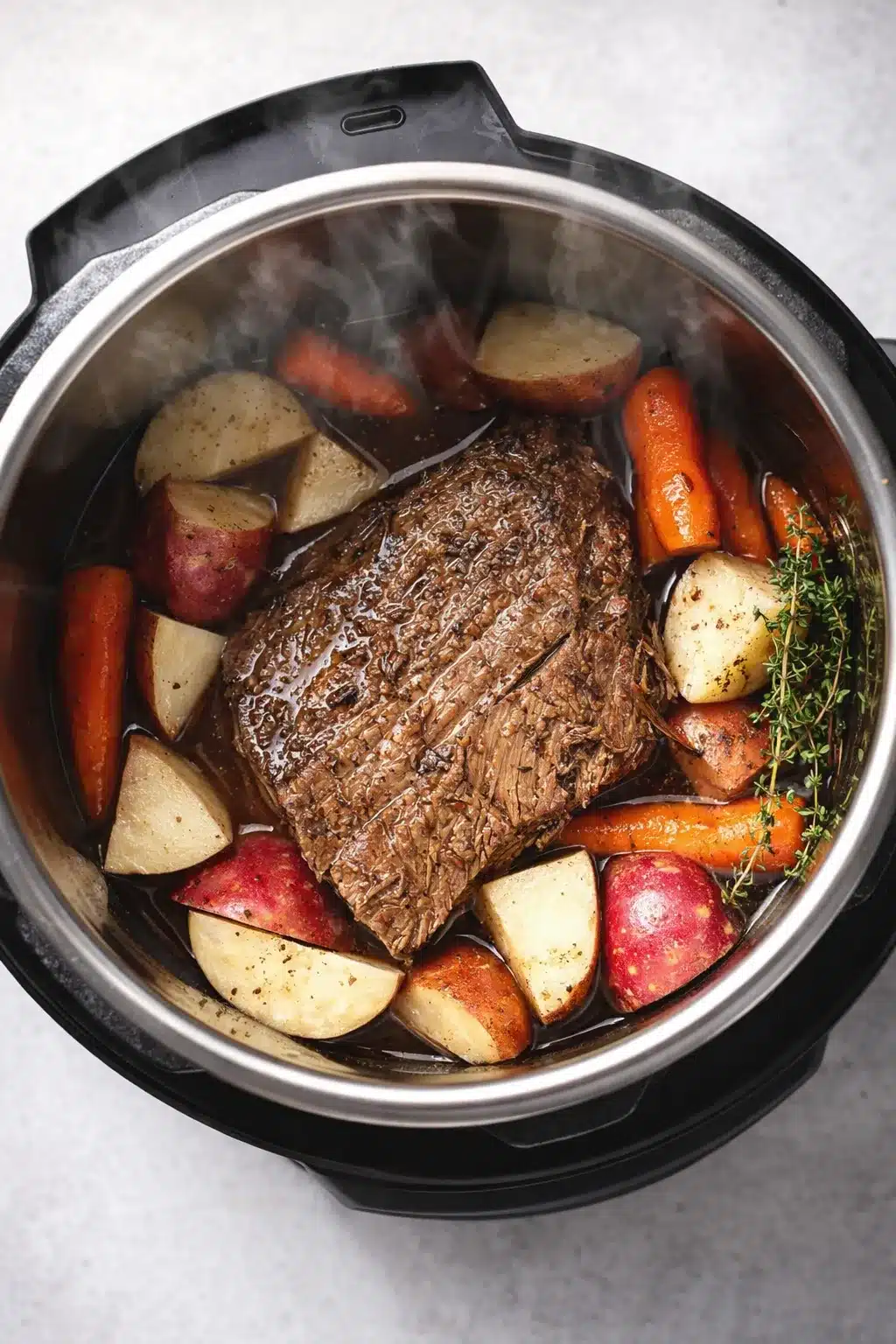 Tender Instant Pot pot roast with carrots and potatoes in savory broth