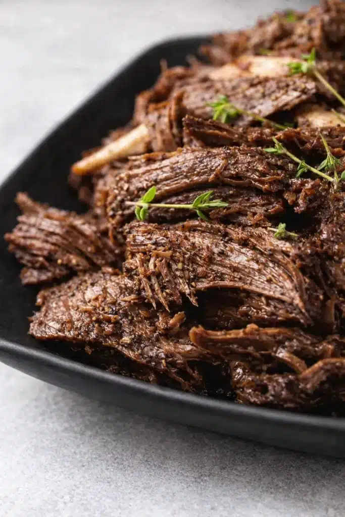 Tender Instant Pot Pot Roast | Ultimate Comfort Dinner 6 Tender shredded Instant Pot pot roast with thyme on black plate