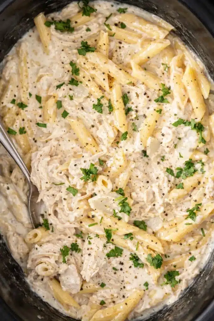Creamy crockpot chicken alfredo pasta with parmesan and parsley