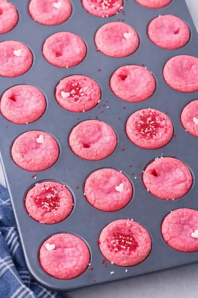 Pink Valentine’s Day cookie cups in mini muffin pan with heart sprinkles