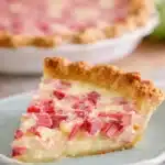 Slice of rhubarb custard pie with creamy filling and golden flaky crust