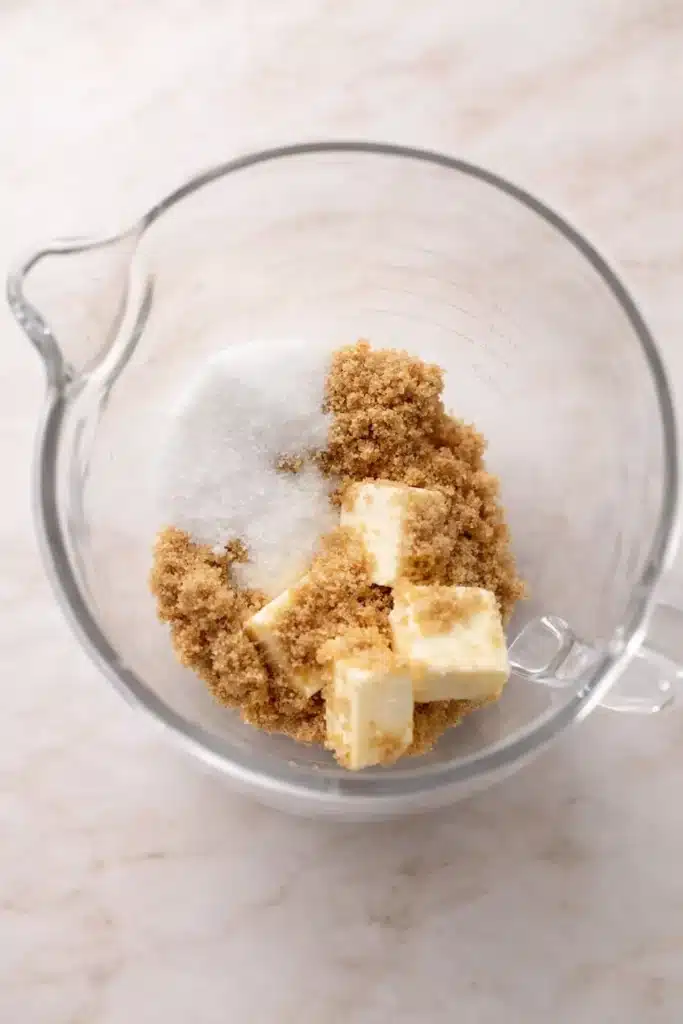 Butter, brown sugar, and white sugar in glass bowl for Easter cookies