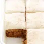 Moist carrot cake bars with cream cheese frosting and cinnamon topping in baking dish