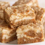 Moist carrot cake bars with cream cheese swirl on a white plate