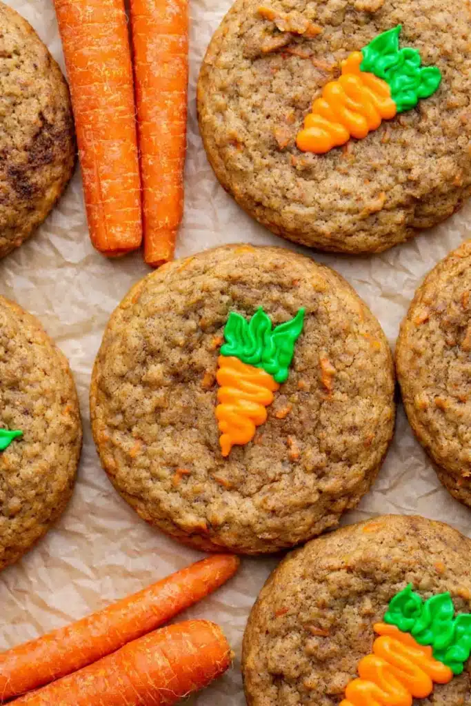 Carrot cake cookies decorated with carrot frosting on parchment paper