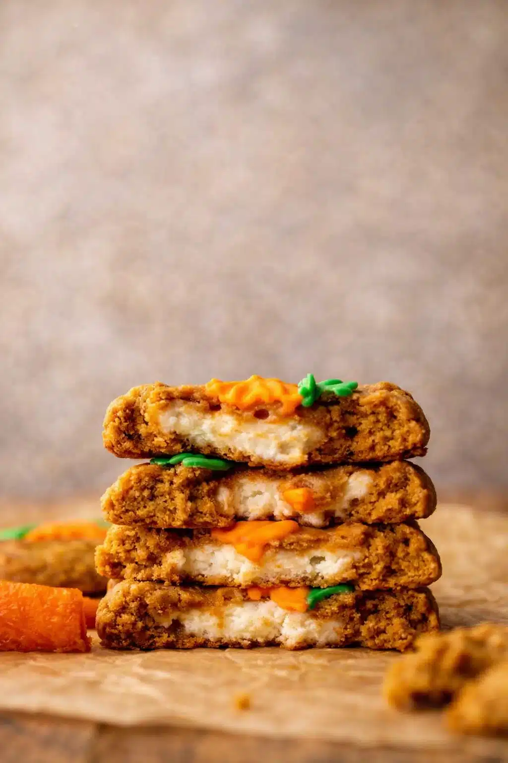 Stack of carrot cake cookies with cream cheese filling and carrot frosting