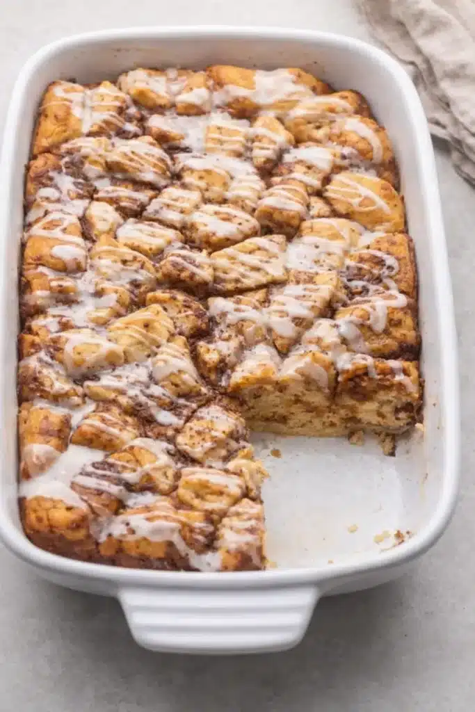 Overhead Cinnamon Roll Casserole with slice removed and vanilla glaze