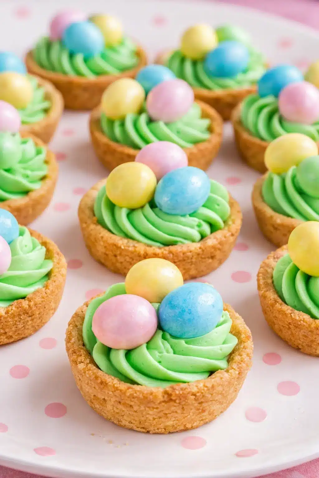 Easter basket sugar cookie cups with green frosting and pastel candy eggs