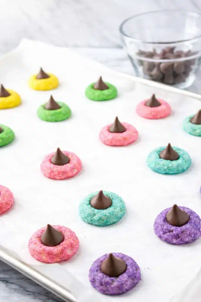 Easter Blossom Cookies cooling on baking tray with colorful sugar and chocolate kisses