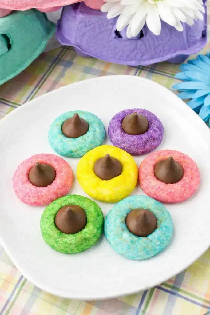Colorful Easter Blossom Cookies arranged on white plate with chocolate kisses