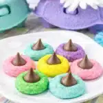 Colorful Easter blossom cookies topped with chocolate kisses on a white plate