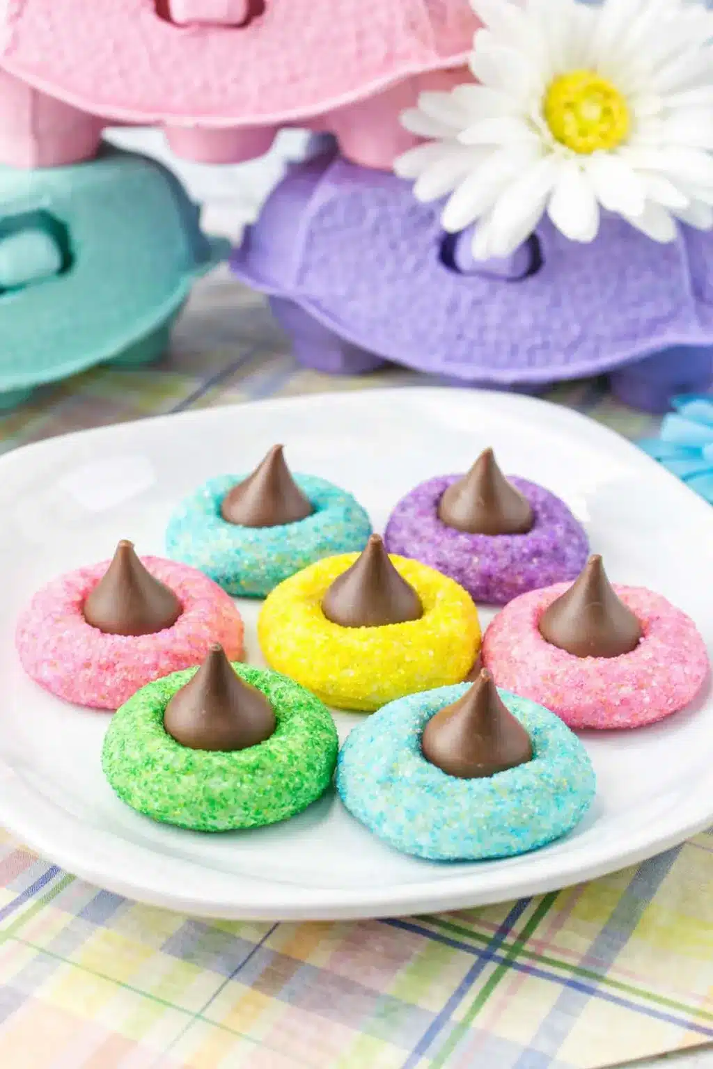 Colorful Easter blossom cookies topped with chocolate kisses on a white plate